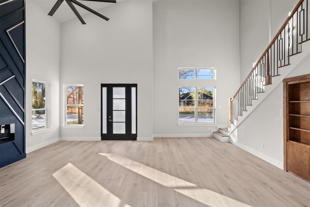 entryway featuring light wood-type flooring and a high ceiling