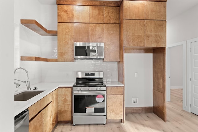 kitchen featuring decorative backsplash, light hardwood / wood-style floors, sink, and stainless steel appliances