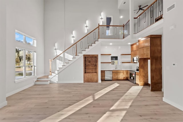 interior space featuring sink, light hardwood / wood-style floors, and a high ceiling