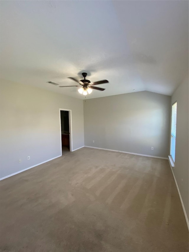 carpeted spare room featuring vaulted ceiling and ceiling fan