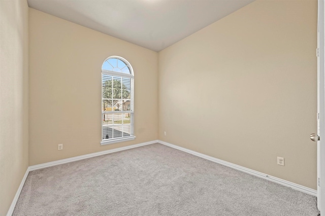 empty room featuring light carpet and vaulted ceiling