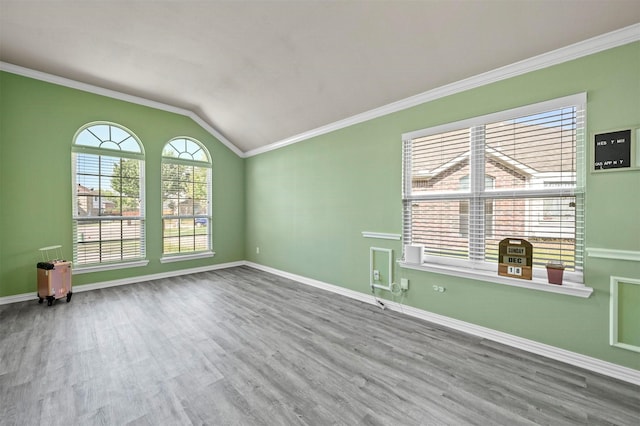 unfurnished room featuring hardwood / wood-style flooring, crown molding, and lofted ceiling