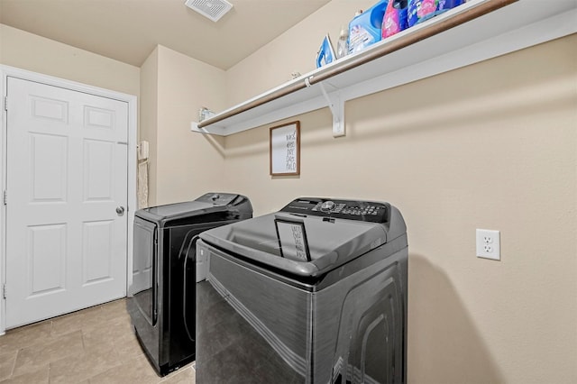 washroom with light tile patterned floors and washer and clothes dryer