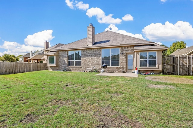 rear view of property with a yard and a patio area