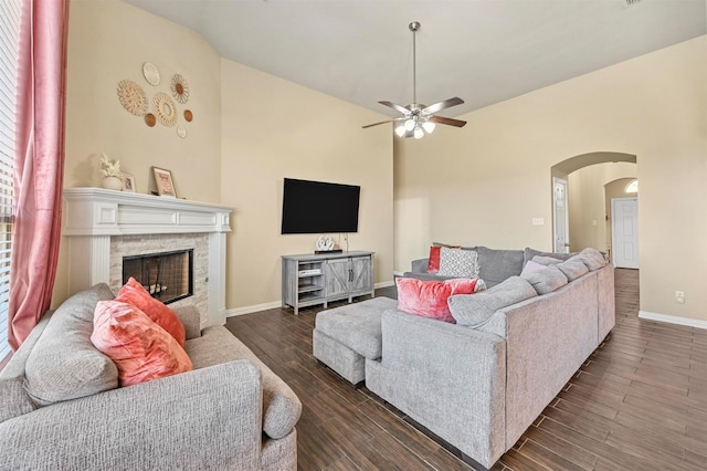 living room with ceiling fan, a fireplace, dark wood-type flooring, and lofted ceiling