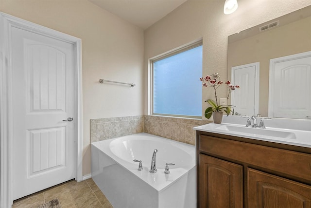 bathroom featuring a bathing tub, tile patterned flooring, and vanity