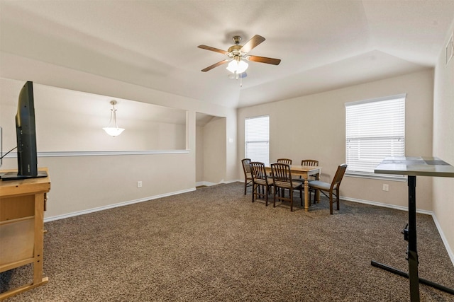 carpeted dining room featuring a tray ceiling and ceiling fan