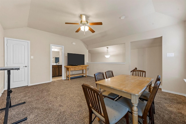 carpeted dining space featuring ceiling fan and vaulted ceiling