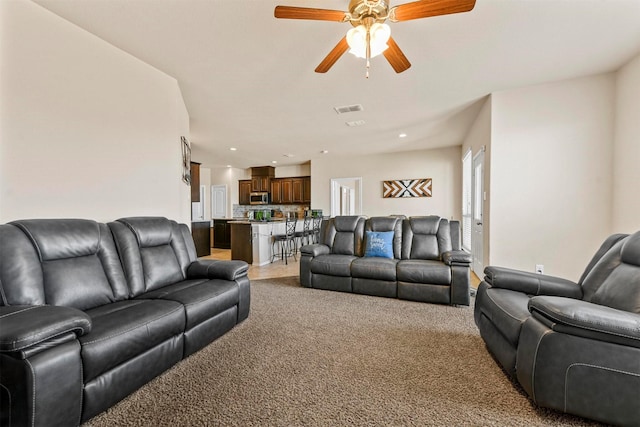 carpeted living room featuring ceiling fan