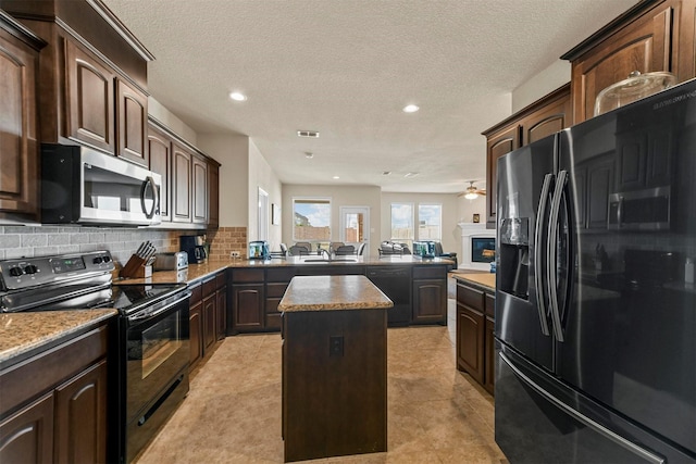 kitchen featuring kitchen peninsula, backsplash, black appliances, light tile patterned floors, and a center island