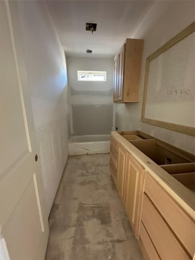 interior space featuring concrete flooring and light brown cabinetry