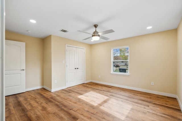 unfurnished bedroom featuring ceiling fan, a closet, and light hardwood / wood-style flooring