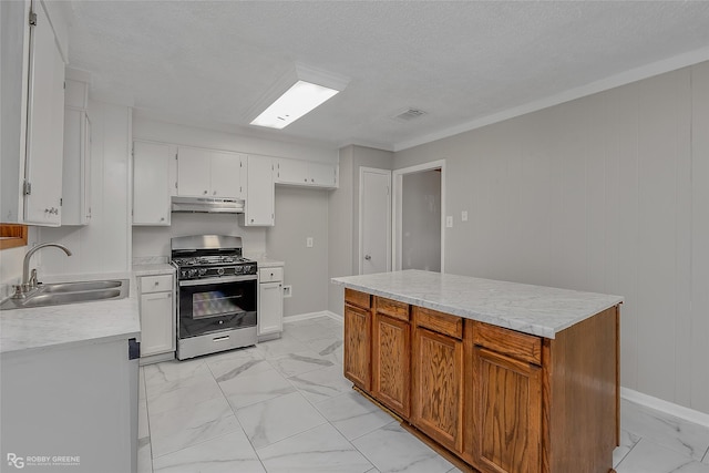 kitchen featuring sink, a kitchen island, a textured ceiling, white cabinets, and gas range