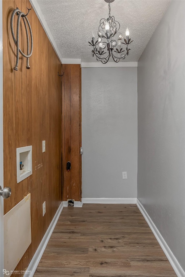 laundry room with washer hookup, dark hardwood / wood-style flooring, a textured ceiling, and an inviting chandelier