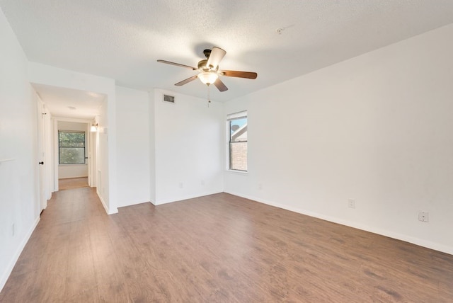 empty room with ceiling fan, hardwood / wood-style floors, and a textured ceiling