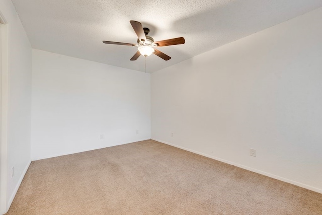 empty room with ceiling fan, light colored carpet, and a textured ceiling