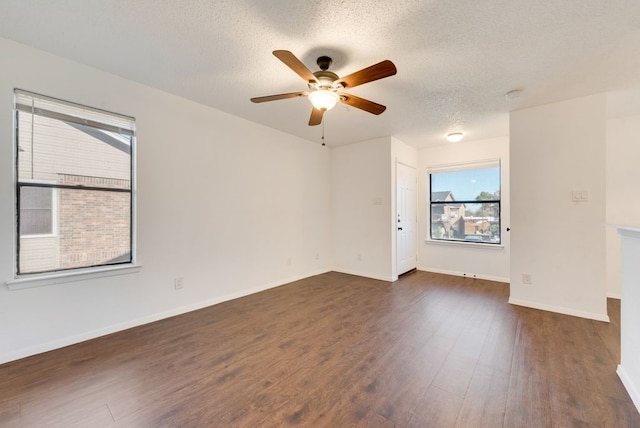 spare room with a textured ceiling, dark hardwood / wood-style flooring, and ceiling fan