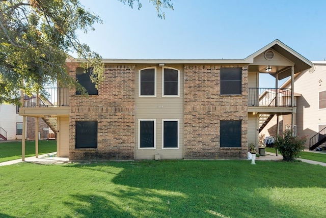 view of front of house featuring a balcony and a front lawn