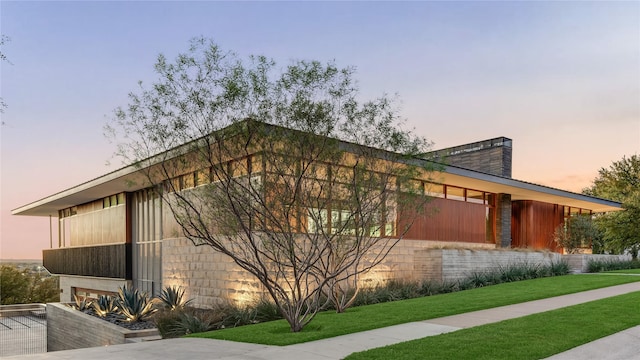 property exterior at dusk with a yard