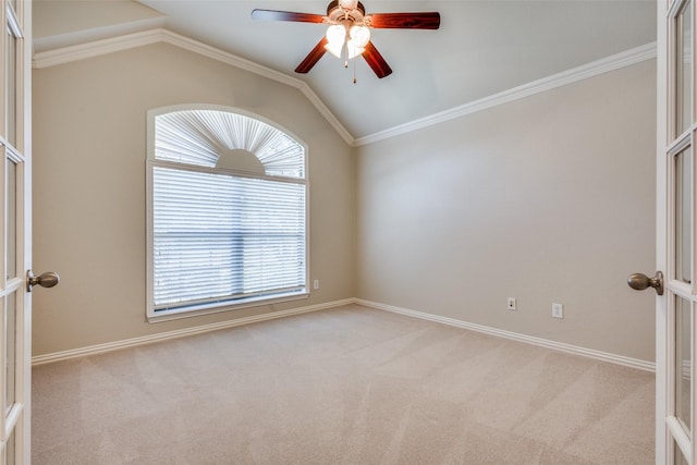 carpeted empty room with ornamental molding, french doors, and vaulted ceiling