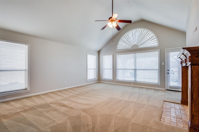 carpeted spare room featuring ceiling fan and high vaulted ceiling