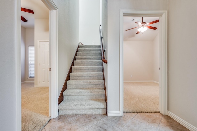 staircase featuring ceiling fan and carpet floors