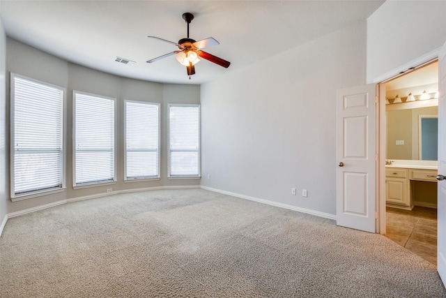 spare room featuring light carpet and ceiling fan