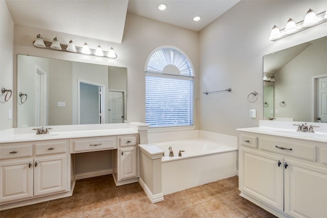 bathroom with tile patterned flooring, vanity, a tub to relax in, and vaulted ceiling