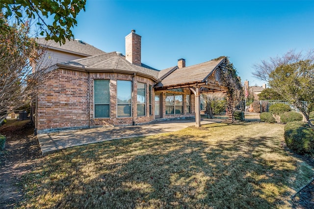 back of house featuring a lawn and a patio area