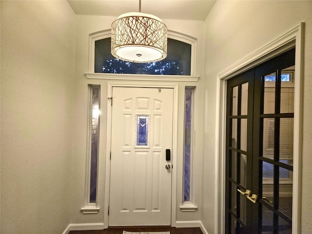 foyer entrance featuring a towering ceiling and french doors