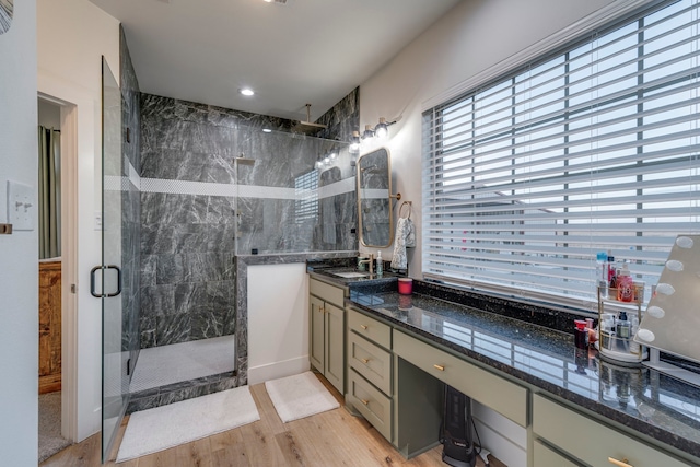 bathroom featuring hardwood / wood-style floors, vanity, and a shower with door