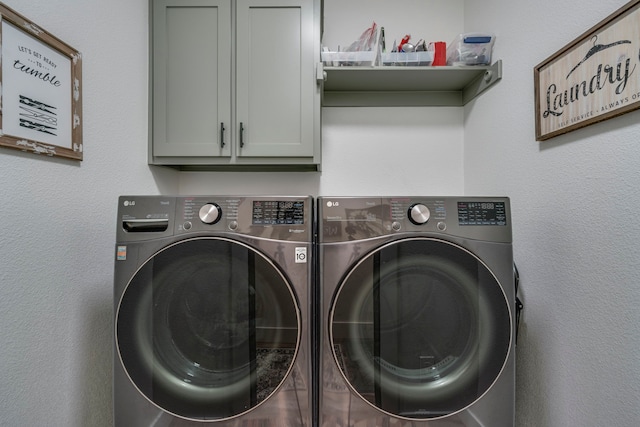 laundry room with cabinets and washing machine and clothes dryer