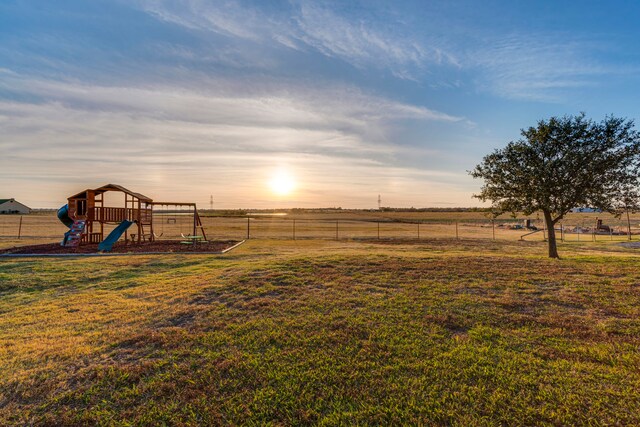 yard at dusk with a playground and a rural view