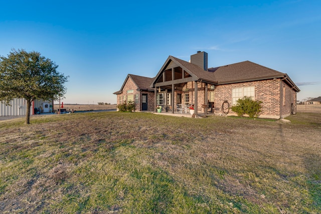 rear view of house with a patio area and a lawn