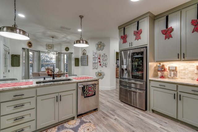 kitchen with gray cabinetry, pendant lighting, sink, decorative backsplash, and stainless steel appliances