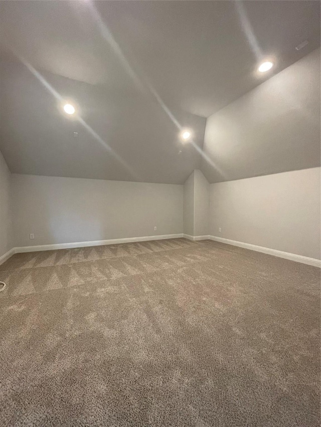 bonus room with carpet flooring and vaulted ceiling