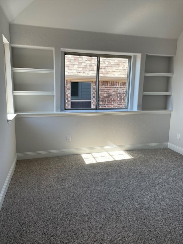 empty room featuring built in features and carpet floors