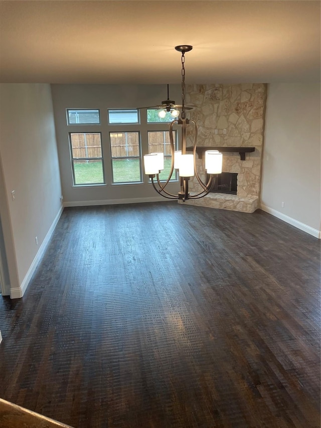 unfurnished dining area with a stone fireplace and dark hardwood / wood-style flooring