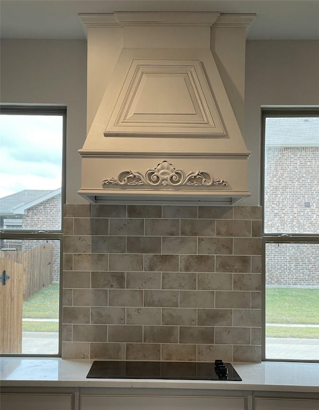 interior details with decorative backsplash and black electric cooktop