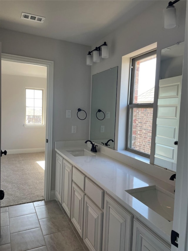 bathroom featuring tile patterned flooring, vanity, and a healthy amount of sunlight