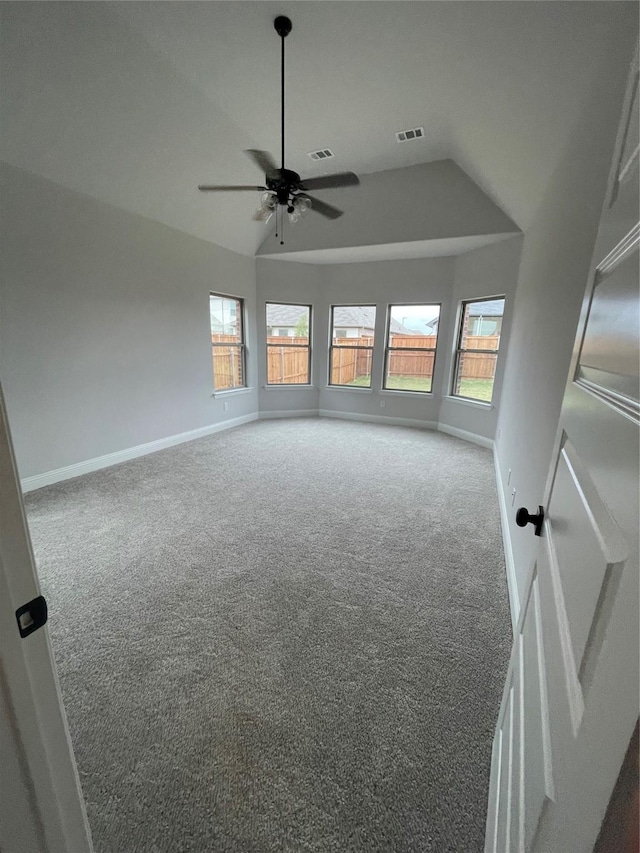 empty room with ceiling fan, carpet floors, and vaulted ceiling