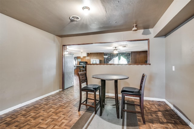 dining space with dark parquet flooring and a textured ceiling