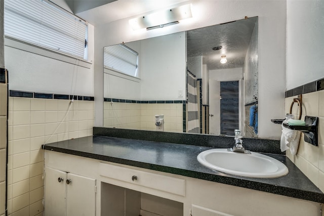 bathroom featuring vanity and tile walls