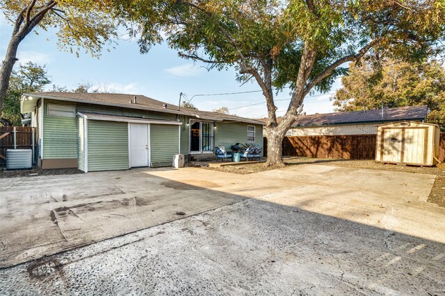 view of front of property with a storage shed, central air condition unit, and a patio