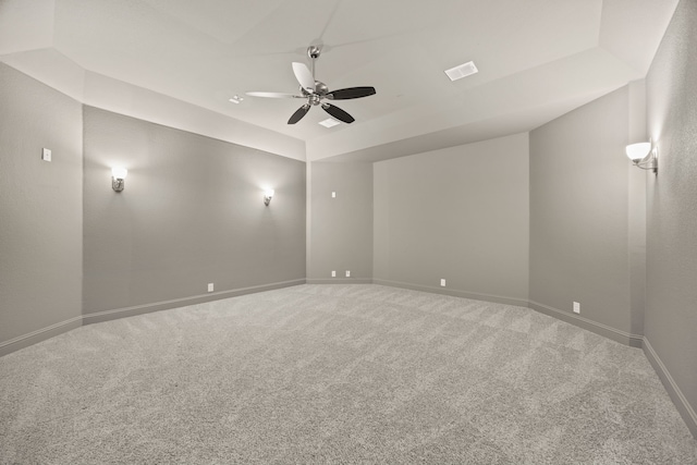 unfurnished room featuring ceiling fan, a raised ceiling, and carpet