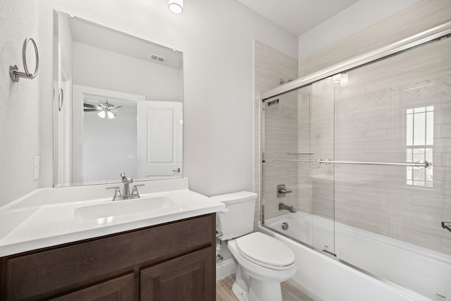 full bathroom with vanity, shower / bath combination with glass door, and toilet