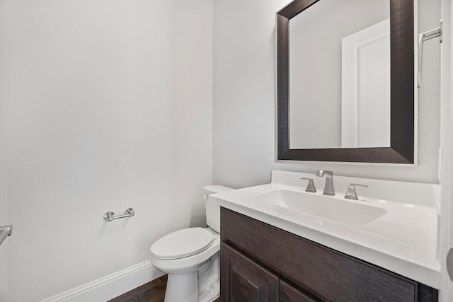 bathroom featuring vanity, hardwood / wood-style flooring, and toilet