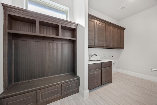 mudroom with sink and light hardwood / wood-style flooring