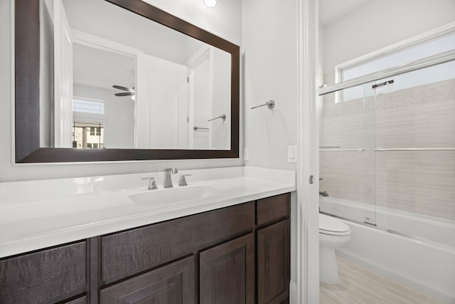 full bathroom featuring vanity, ceiling fan, bath / shower combo with glass door, and toilet