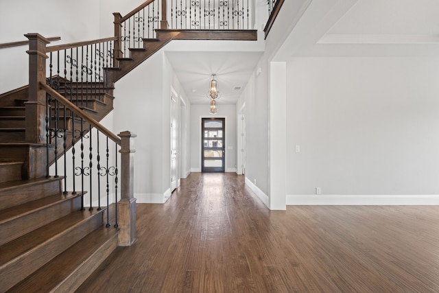 entrance foyer featuring hardwood / wood-style flooring and a towering ceiling